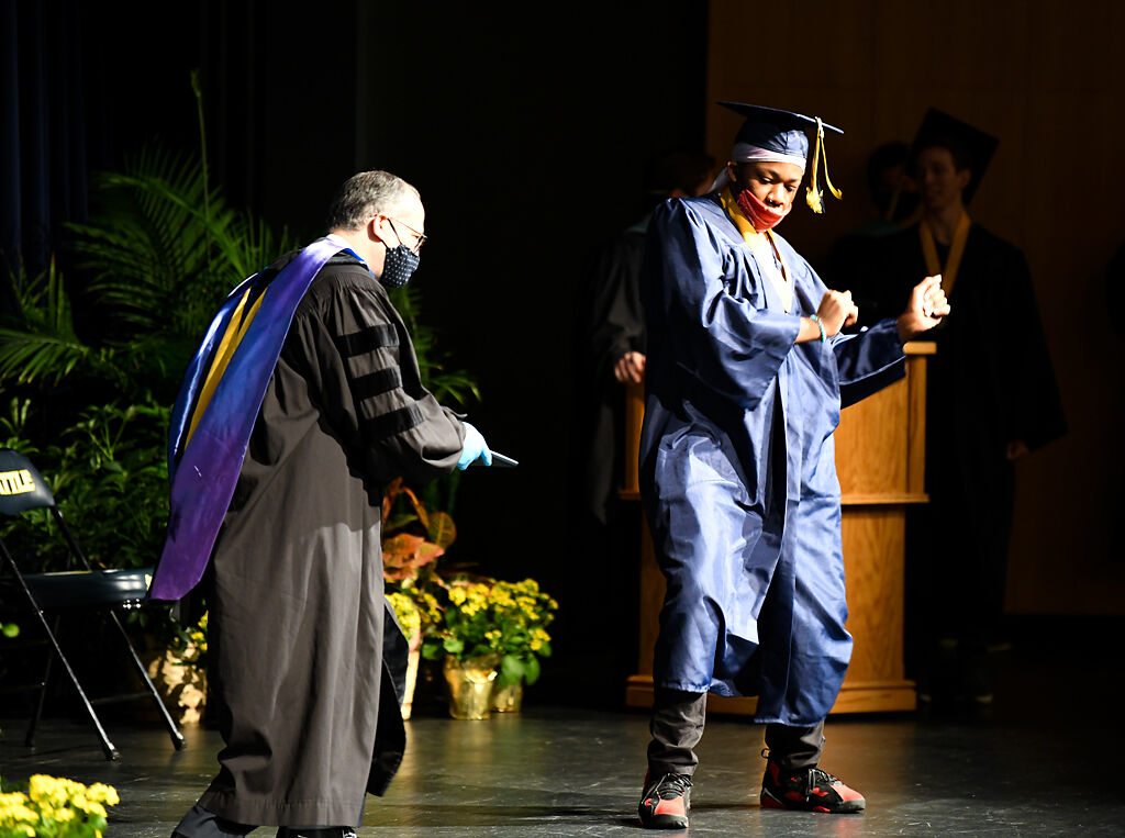 Dennis Darks dances across the stage to receive his diploma
